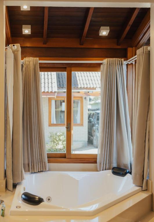 a window with a bath tub in a room at Cabanas Belo Destino in Gramado