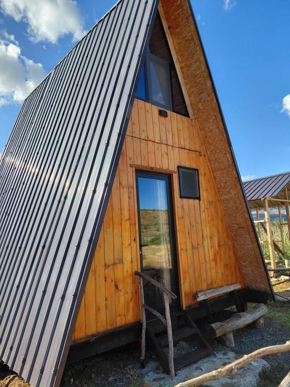 a wooden cabin with a gambrel roof at Cozy Lakefront Cabin - Myselim in Shkodër