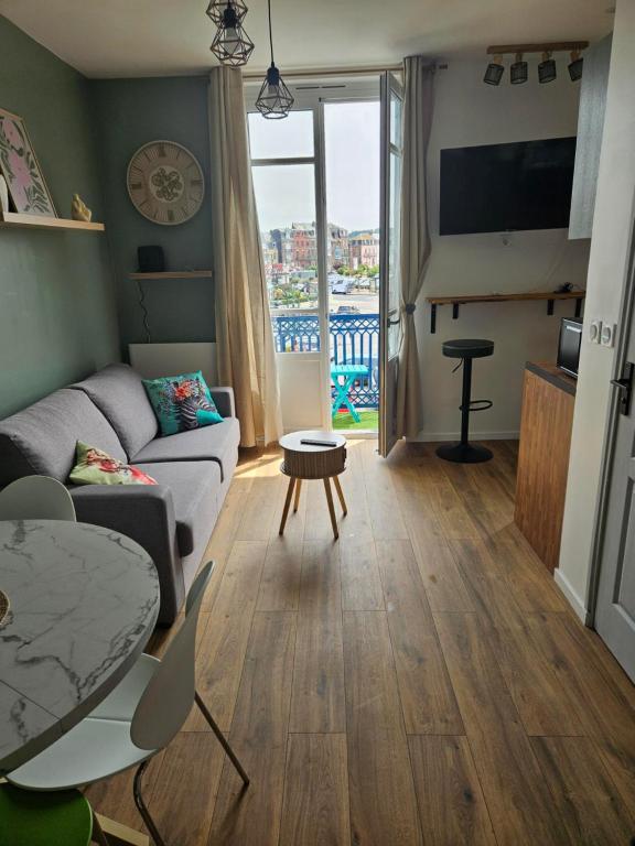a living room with a couch and a table at Le coeur de Mers in Mers-les-Bains