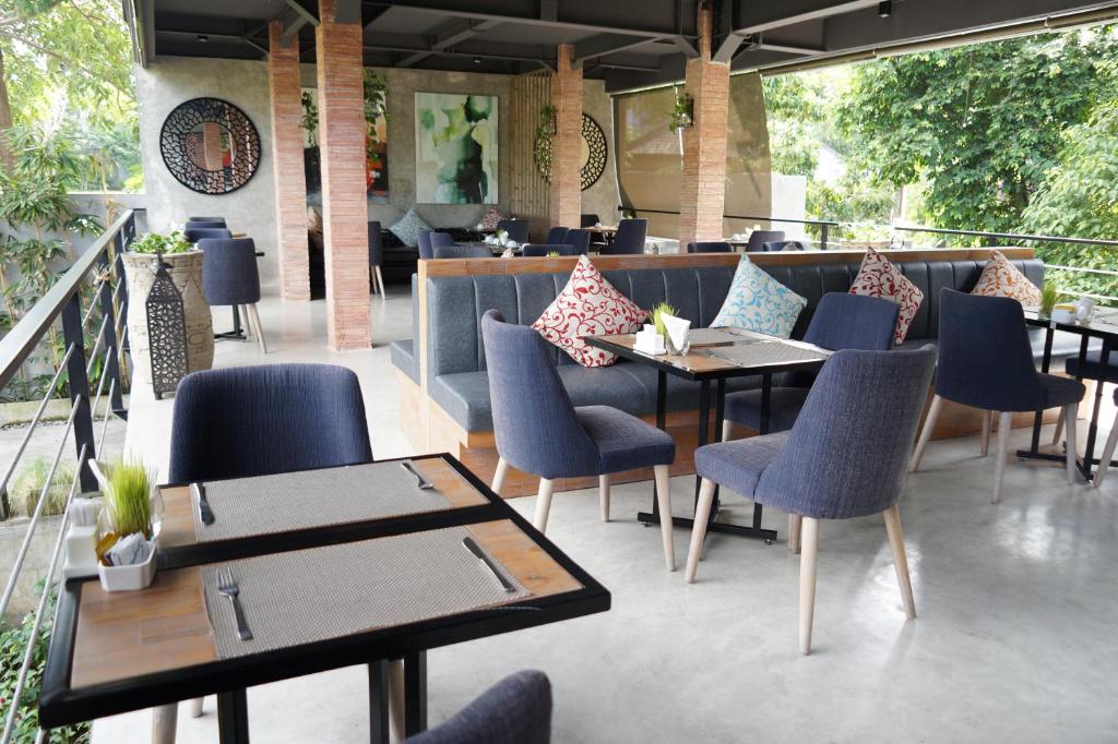 a restaurant with tables and chairs and a bar at Maca Villas and Residence Umalas in Seminyak