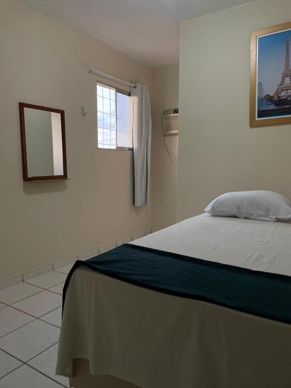 a bedroom with a bed with a mirror and a window at Pousada BR 423 in Garanhuns