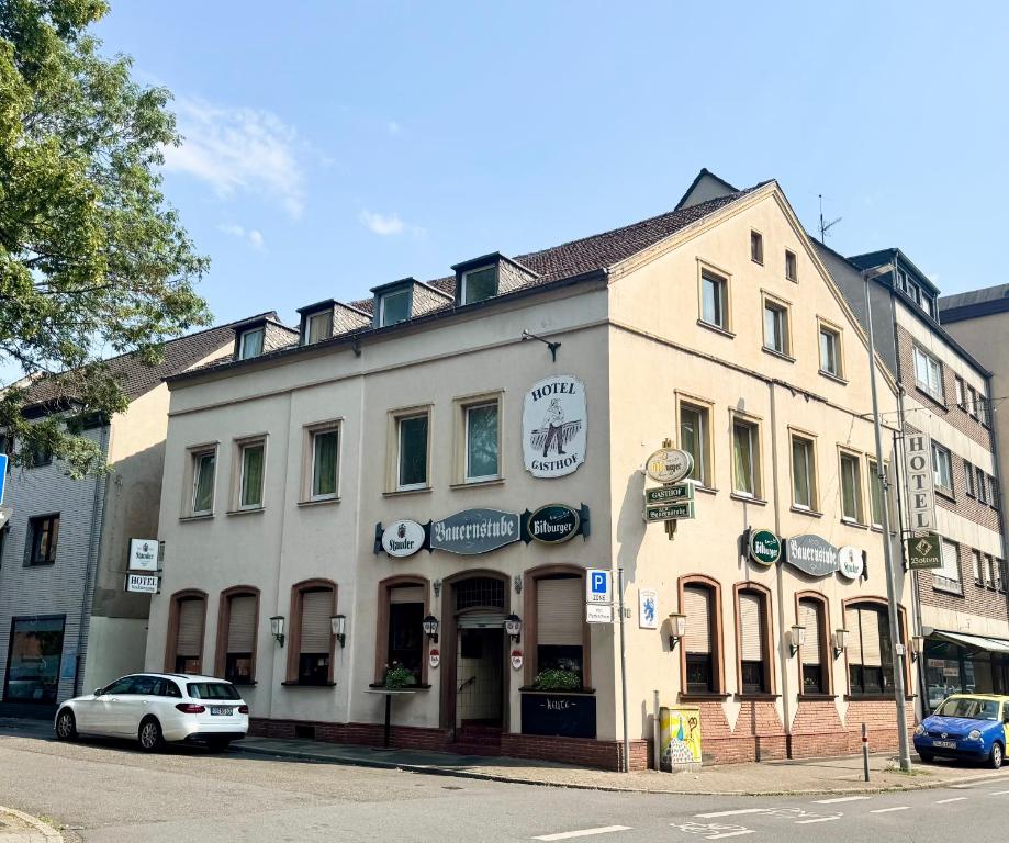 a white building on the corner of a street at Hotel Bauernstube in Oberhausen
