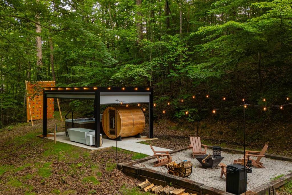 a shed with a barrel in the middle of a forest at S'more Memories-Cold Plunge, Sauna, Hot Tub Wellness Retreat in Campton