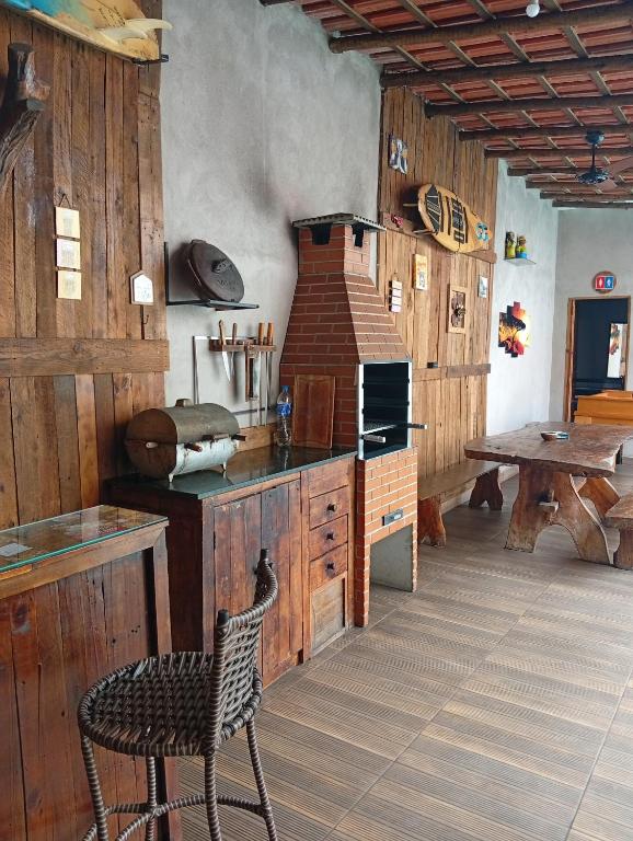 a kitchen with wooden walls and a table and a chair at Casacapuba Jacaraipe Es in Serra
