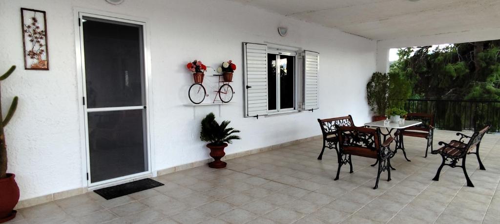 a patio with a table and chairs and a window at Irida Suite in Salamina