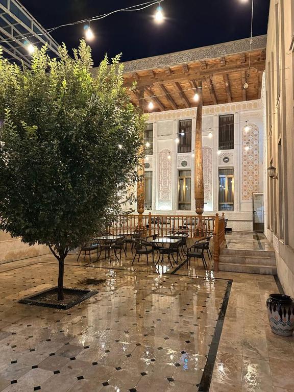 a courtyard with tables and chairs and a tree at Orom Hotel & Terrace in Bukhara