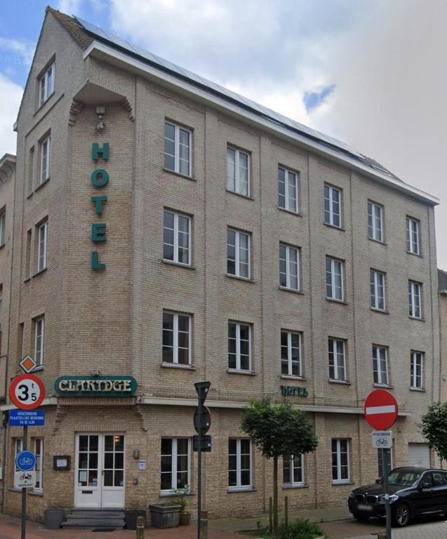 ein großes Backsteingebäude mit einem Schild darauf in der Unterkunft Hotel Claridge in Blankenberge