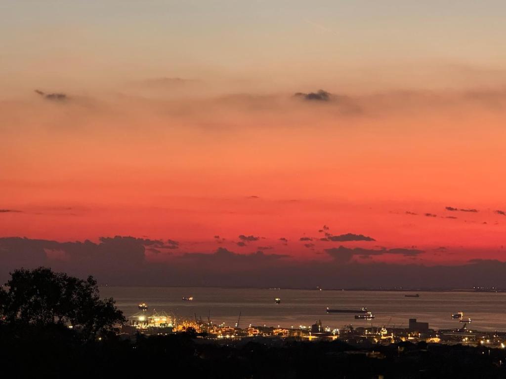 a sunset over the water and a city at Apartma Olive & Spice in Koper