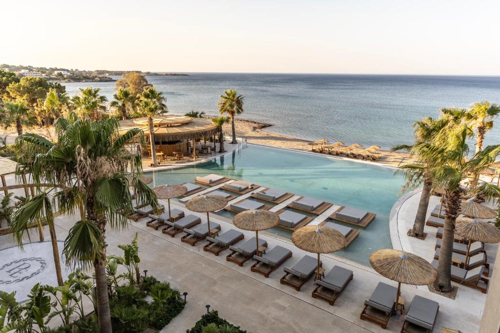 an aerial view of a resort pool with chairs and umbrellas at Pefkian Ethos Hotel & Suites in Pefki