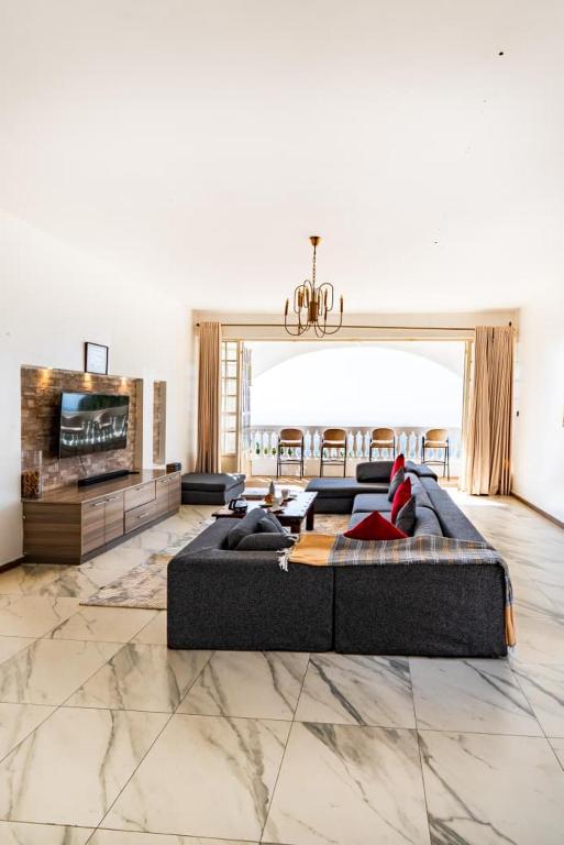 a large living room with a couch and a tv at White Hill Penthouse in Kisumu