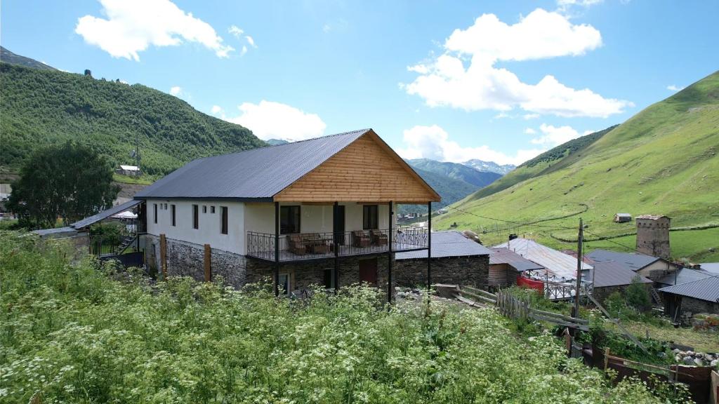 a building with a roof on top of a mountain at Hotel - Old Ushguli in Ushguli
