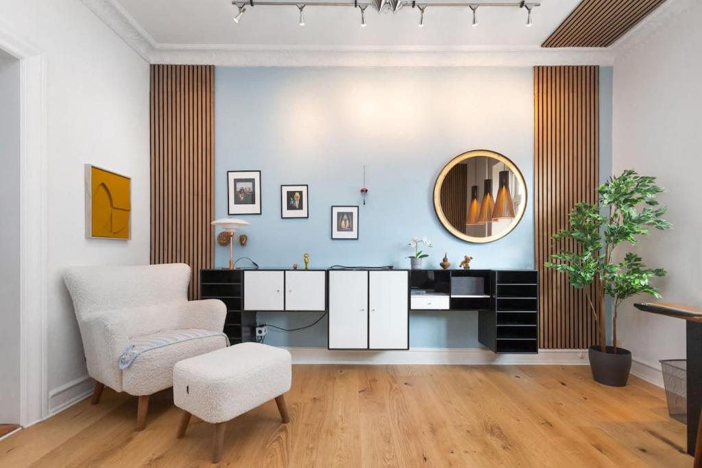 a living room with a chair and a mirror at Central Jylland Suite in Aalborg