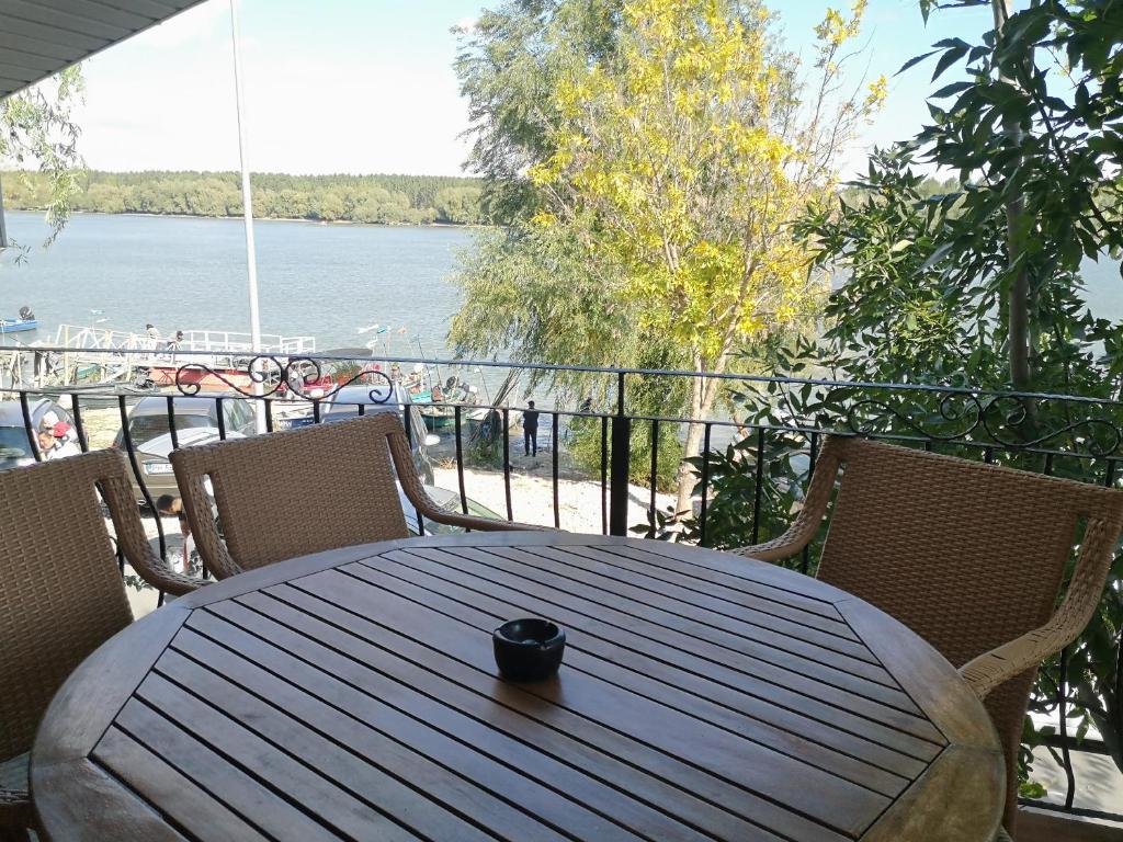 a wooden table on a balcony with a view of the water at Vila VERA in Mahmudia