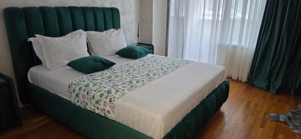 a bedroom with a bed with green headboard and pillows at Apartament Victoriei - Centru in Bucharest