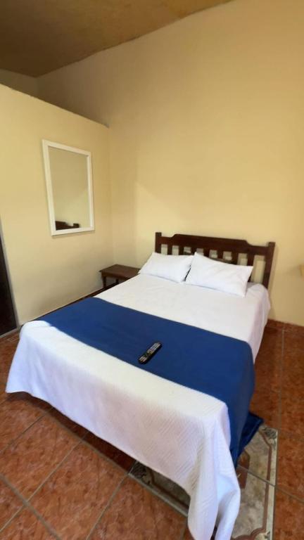a bedroom with a large bed with a blue blanket at Accommodation #7 in Copán Ruinas