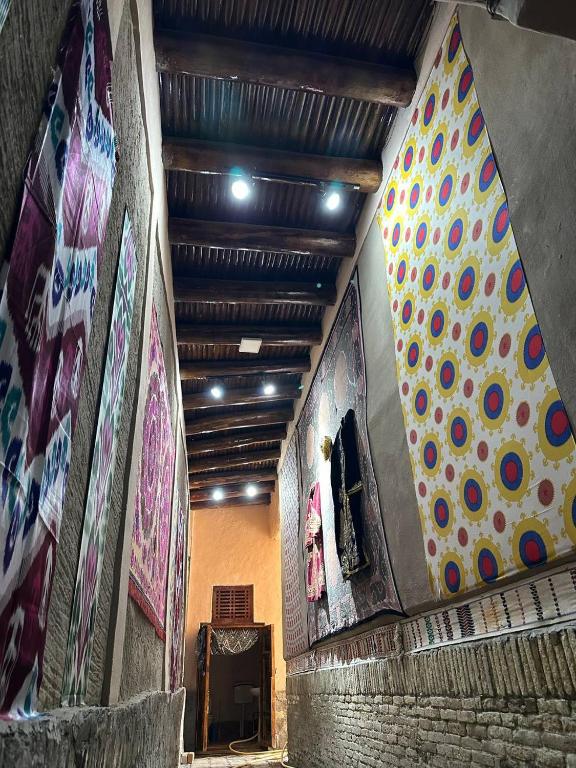 a hallway with paintings on the walls of a building at Merik Boutique in Bukhara