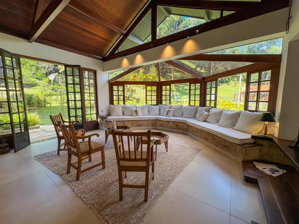 a living room with a large couch and chairs at Casa 02 Vale Boa Vista - Casa em Condomínio Exclusivo com Vista para as Montanhas e Área de Lazer Completa in Teresópolis