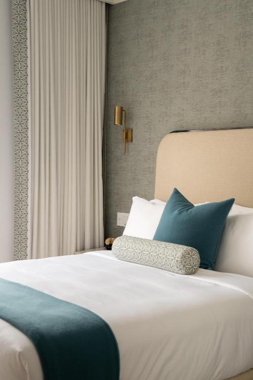 a bedroom with a large bed with blue pillows at Manoir Émery in Montreal