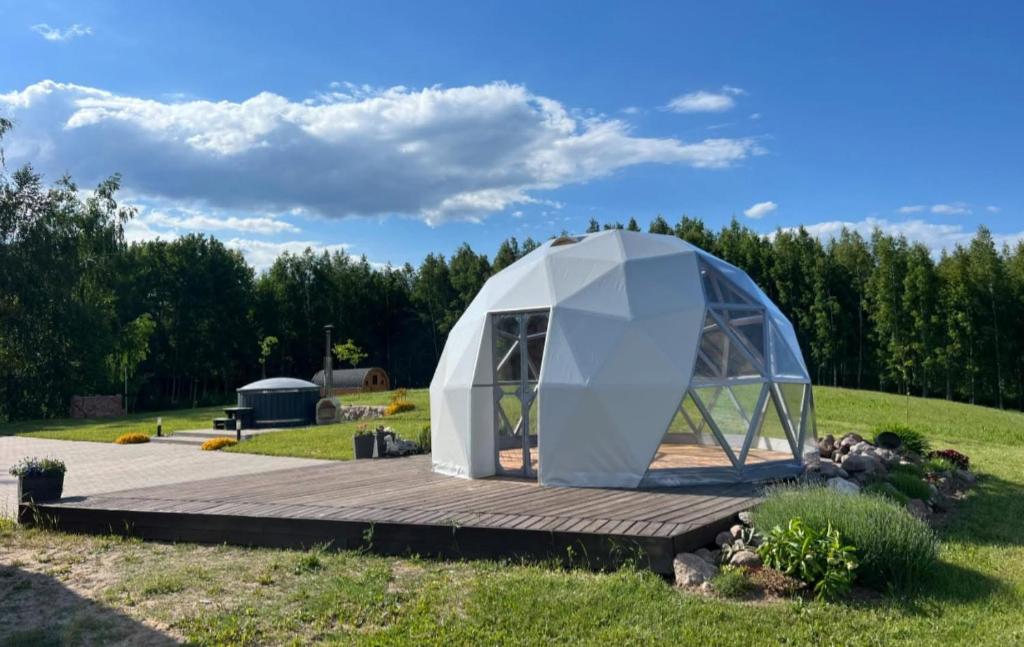 a white dome tent sitting on a wooden deck at Poilsio oazė Stebuliuose in Stebuliai
