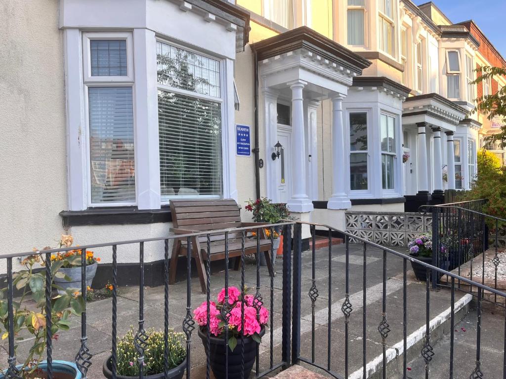 a house with a bench and flowers in front of it at Seaview Inn in Southport