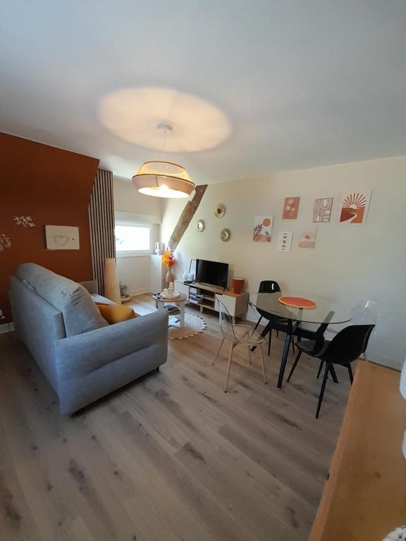a living room with a couch and a table at Le clos de Tallann in Guénin