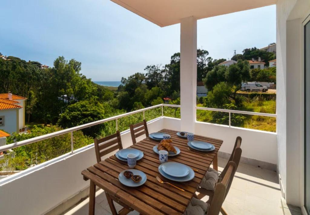 a wooden table on the balcony of a house at Cascais, Family retreat in a 2-bedroom apartment in Alcabideche