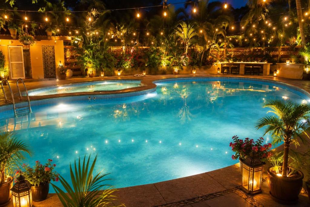 a large swimming pool at night with lights at Tripo bay inn in Mahabalipuram