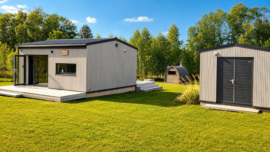a tiny house in a yard with a garage at Elenos sodyba in Puorai