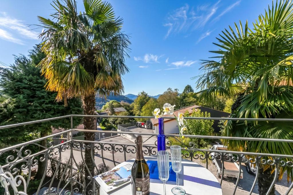 a table with a bottle of wine on a balcony at Casa Naima: Family House | Terrace & Peaceful Location - Happy Rentals in Breno
