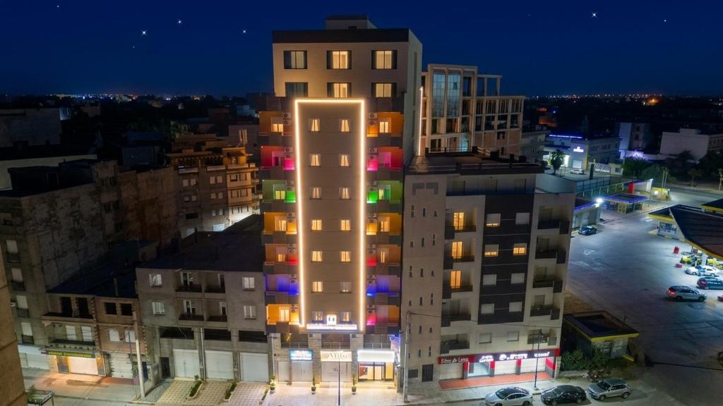 a tall building with illuminated windows at night at Hostel Bouchair Centre Ville Jijel in Jijel