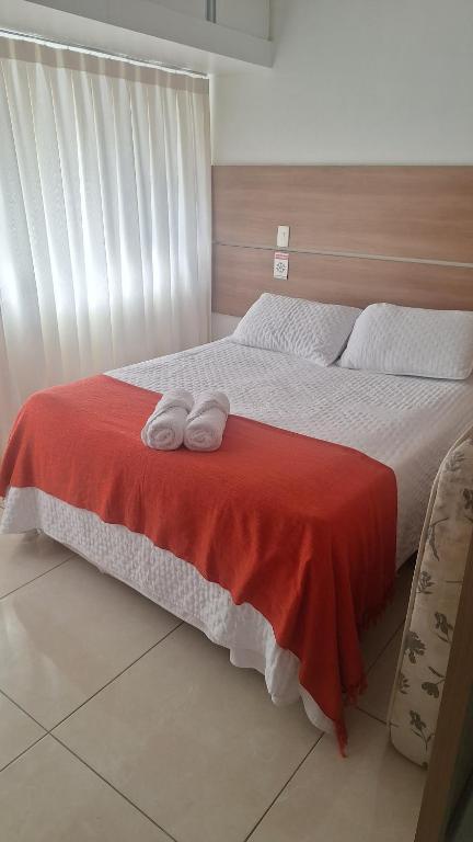 a bedroom with a bed with two towels on it at Estúdio Ibiza em Jatiúca in Maceió