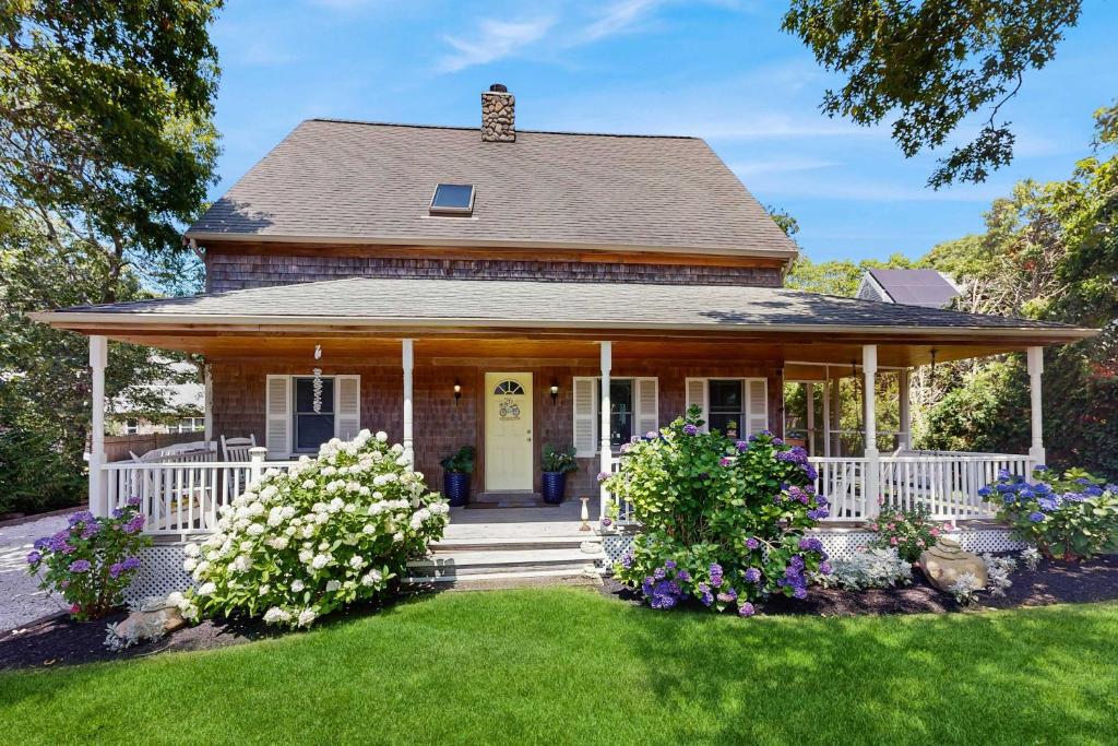 a house with a porch with flowers in the yard at Sunny Side Up in Oak Bluffs