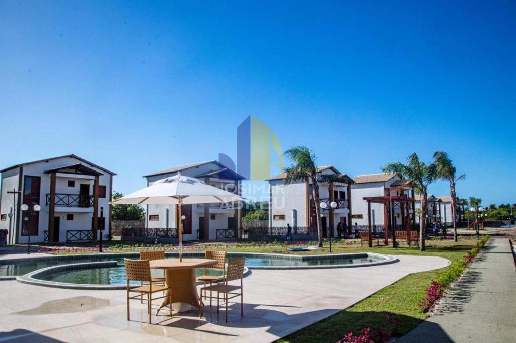a patio with a table and chairs and a building at Atins Brisa in Barreirinhas