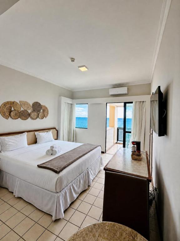 a hotel room with a bed and a television and a room at Flat Costa Mar in Recife