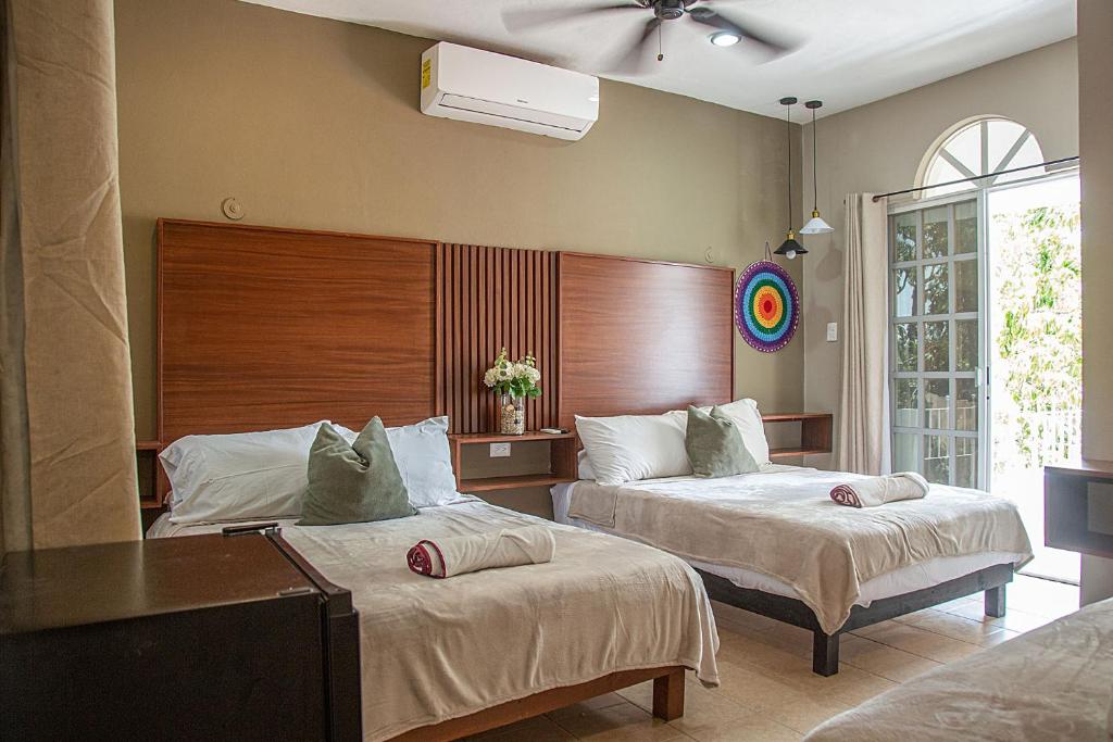 a bedroom with two beds and a window at Villas Aura in Mérida