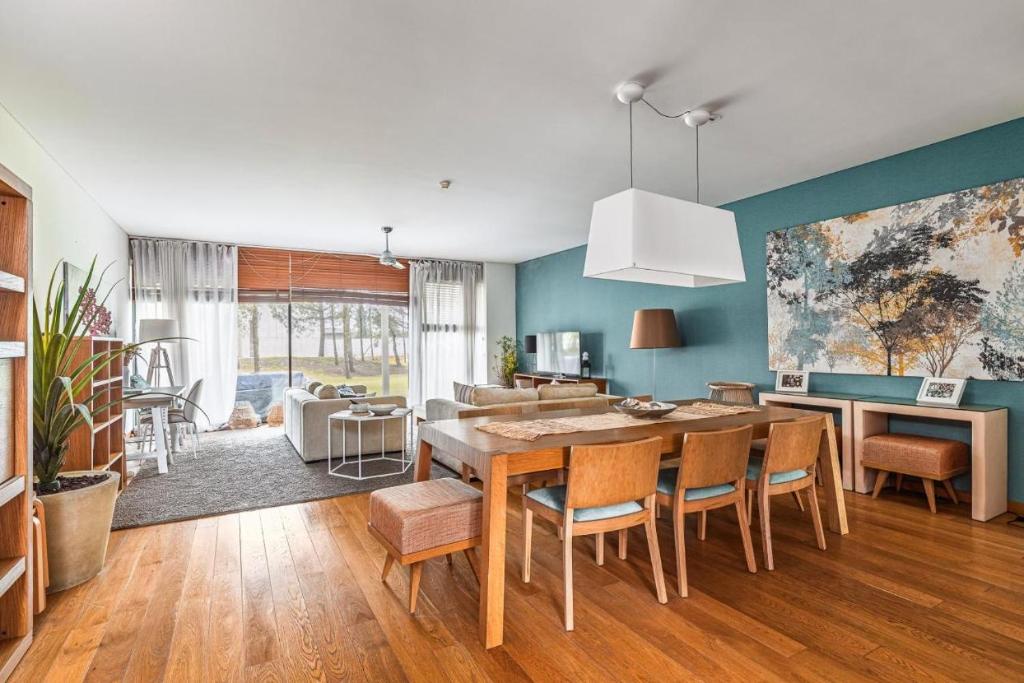 a dining room with a table and chairs and a living room at Summer Villa in Troia