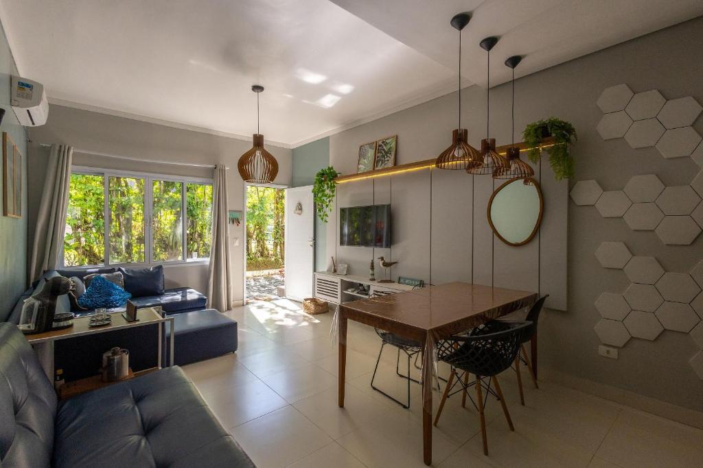 a living room with a table and a couch at Flat completo e charmoso no centro de Juquehy in São Sebastião