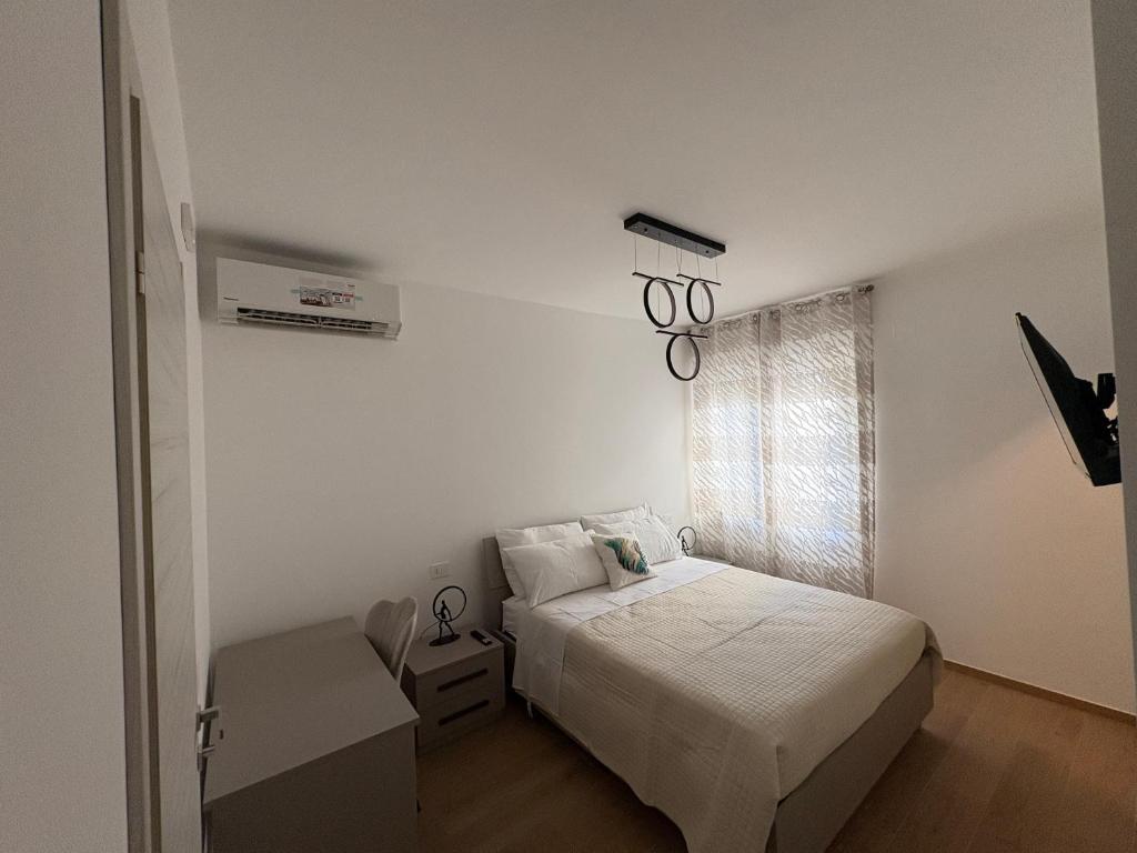 a white bedroom with a bed and a window at Colombo Boutique Rooms in Tortoreto Lido