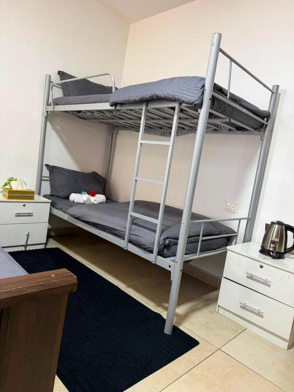 a room with two bunk beds and a desk at MBZ - Boutique Bed Space in Muşaffaḩ