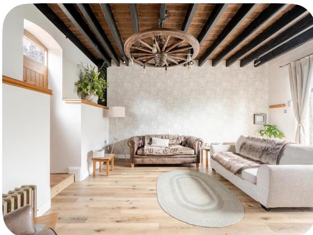a living room with a couch and a chandelier at The Hurst Stable Sleeps 4 with Hot Tub & Parking in Stafford