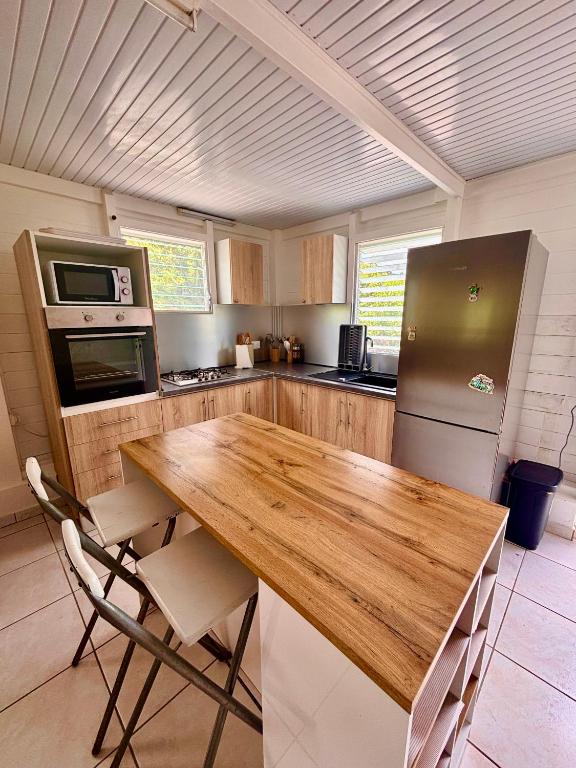 a kitchen with a wooden table and a refrigerator at Kaz alizé in Sainte-Marie