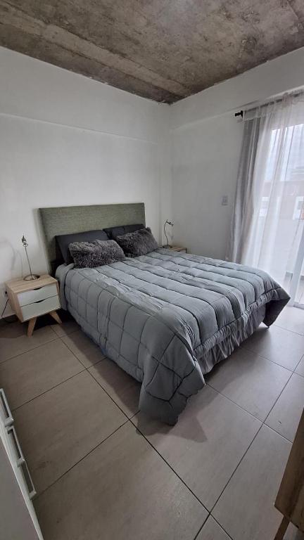 a bedroom with a large bed in a white room at Apartment Z Alberdi Home in Belén de Escobar