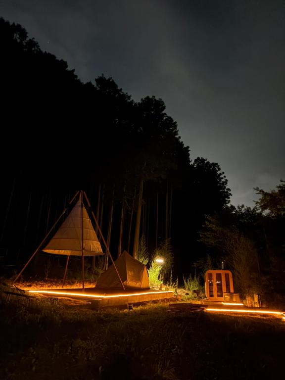 a tent in the middle of a field at night at 川辺の時-Kawabe 川-山-BBQ in Hanno