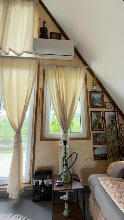 a living room with two windows and a couch at Vrela Holiday Home in Cetinje