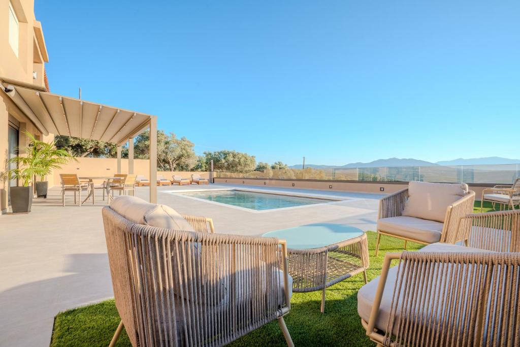 a patio with two chairs and a swimming pool at Nautilus Villa - Private Pool II in Elaía