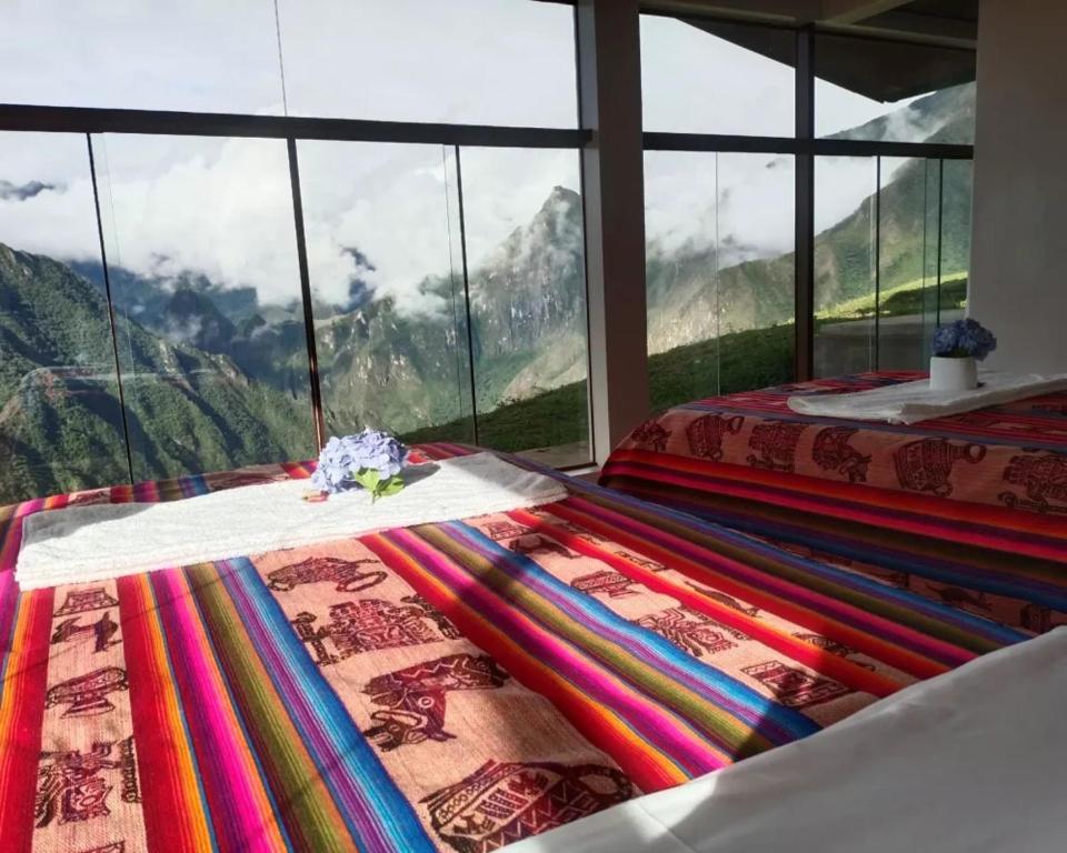 a bedroom with a bed with a view of mountains at Llactapata Lodge overlooking Machu Picchu - camping - restaurant in Santa Teresa