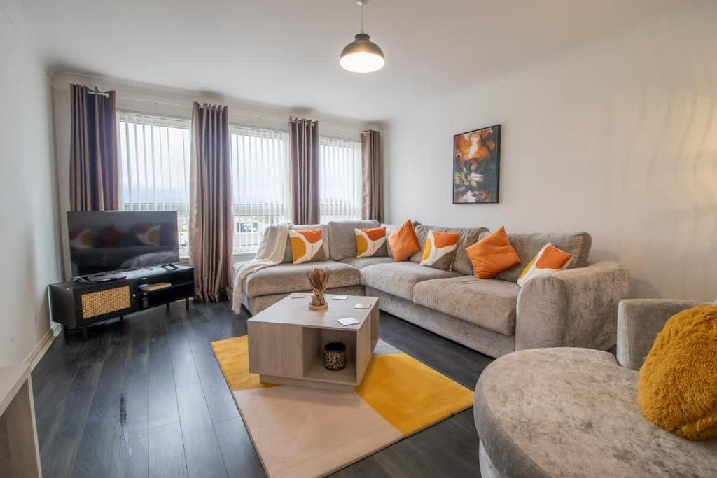 a living room with a couch and a table at Park View-modern 2 bed apartment in Motherwell