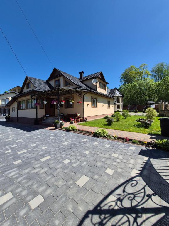 a house with a brick driveway in front of a house at Mlynski in Mykulychyn