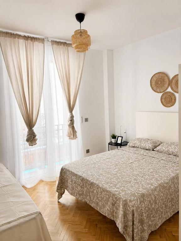a bedroom with a bed and a large window at Gato street, Private rooms in Madrid
