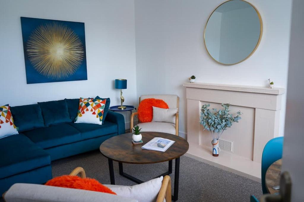 a living room with a blue couch and a table at Park House - 3 bedroom in Portsoy
